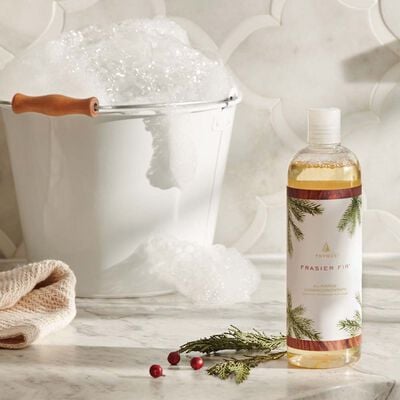 Thymes Frasier Fir All-Purpose Cleaning Concentrate on kitchen counter next to a warm bucket of water